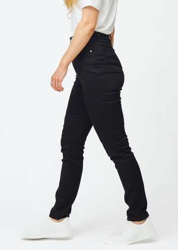 Black high-waisted slim jeans seen from the side on a model.