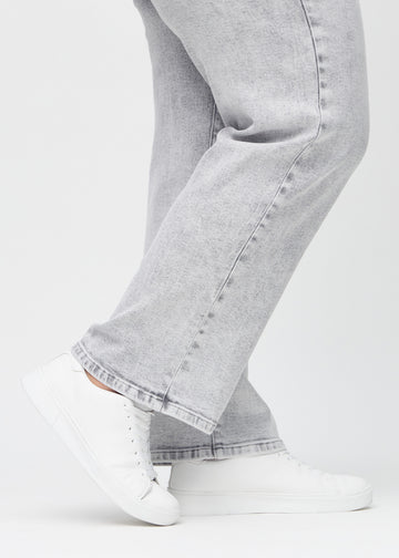 The ankles of a plus-size model, so you can see how loosely the jeans fit.
