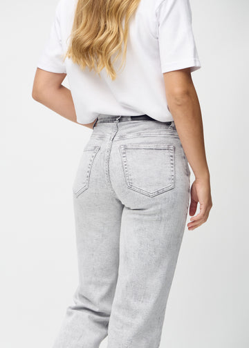 Light grey denim loose jeans seen from the back close up to show details.