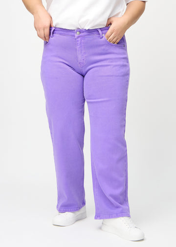 Loose jeans for women in purple, color Lavenders. Front view on a plus-size model, showing the roomy, wide-leg fit.