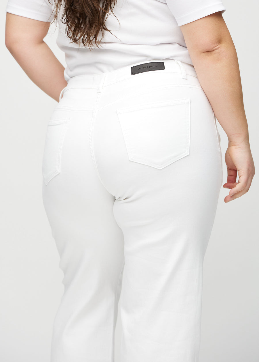 White loose jeans seen from the back close up on a plus-size model to show details.