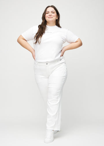 Full image of a plus-size model in white loose jeans.