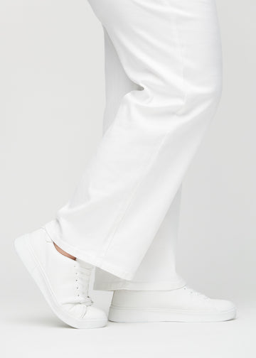 The ankles of a plus-size model, so you can see how loose the jeans fit.