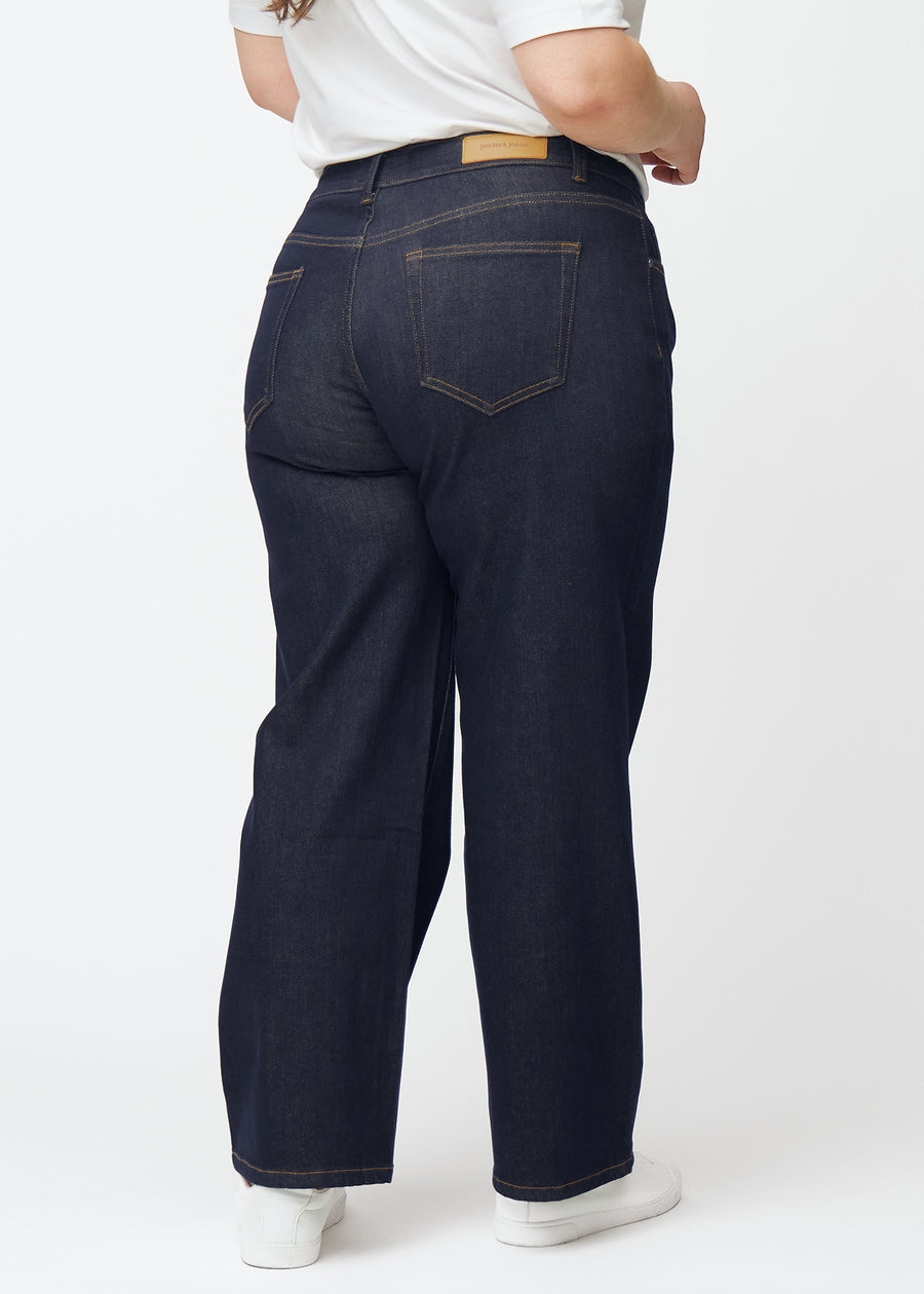 Deep dark blue denim jeans for women in the color Midnights shown from the back on a plus-size model.