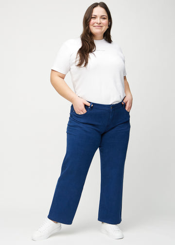Full image of a plus-size model in dark blue loose jeans.