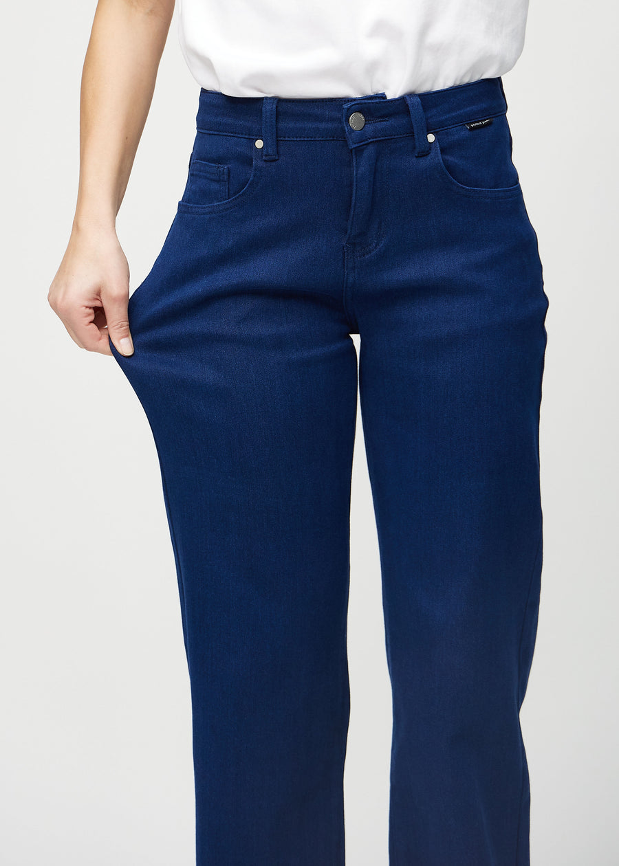The model stretches the jeans at the thigh to show the stretch.