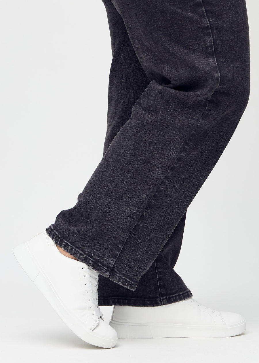 Loose jeans for women in dark grey, color Shadows. Close-up at the ankles on a plus-size model, showing the wide leg openings.