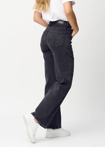 Loose jeans for women in dark grey, color Shadows. Back view on a model, showing the overall relaxed fit.