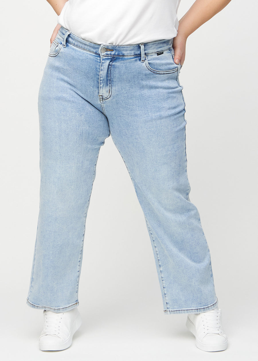 Light denim loose jeans, model name Waves, which is loose-fitting with plenty of width in the legs on a plus-size model, seen from the front.