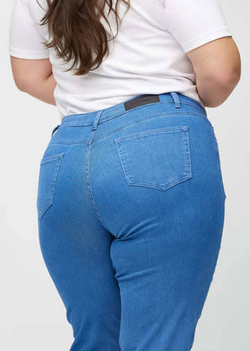 Regular jeans for women in blue, color Geraniums. Close-up from behind on a plus-size model, showing fit and details.