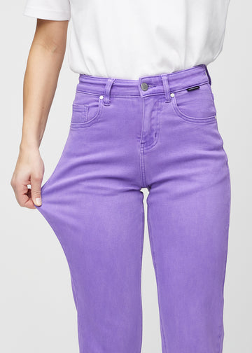 Regular jeans for women in purple, color Lavenders. A model stretches the fabric at the thigh to show its stretch.