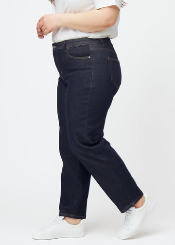 Deep dark blue denim jeans for women in the color Midnights with a regular fit, seen from the side on a plus-size model.