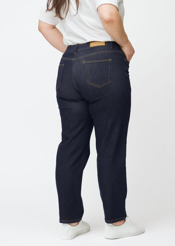 Deep dark blue denim jeans for women in the color Midnights, seen from the back on a plus-size model.