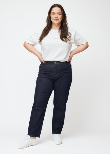 Full-length image of a plus-size model in deep dark blue denim jeans for women in the color Midnights with a regular fit.