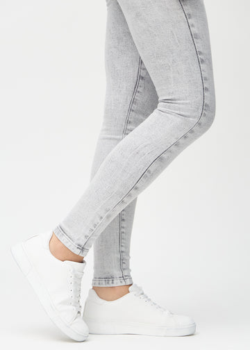 Skinny jeans for women in light grey, color Ashes. Close-up of the snug-fitting leg openings at the ankles on a model.