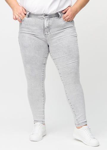 Skinny jeans for women in light grey, color Ashes. Front view on a plus-size model, showing the close fit through the legs.