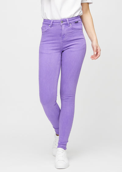 Skinny jeans for women in purple, color Lavenders. Front view on a model, showing the close fit through the legs.