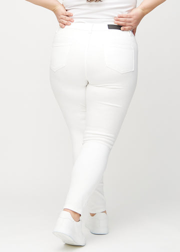 White skinny jeans seen from the back on a plus-size model, so the entire product can be seen.