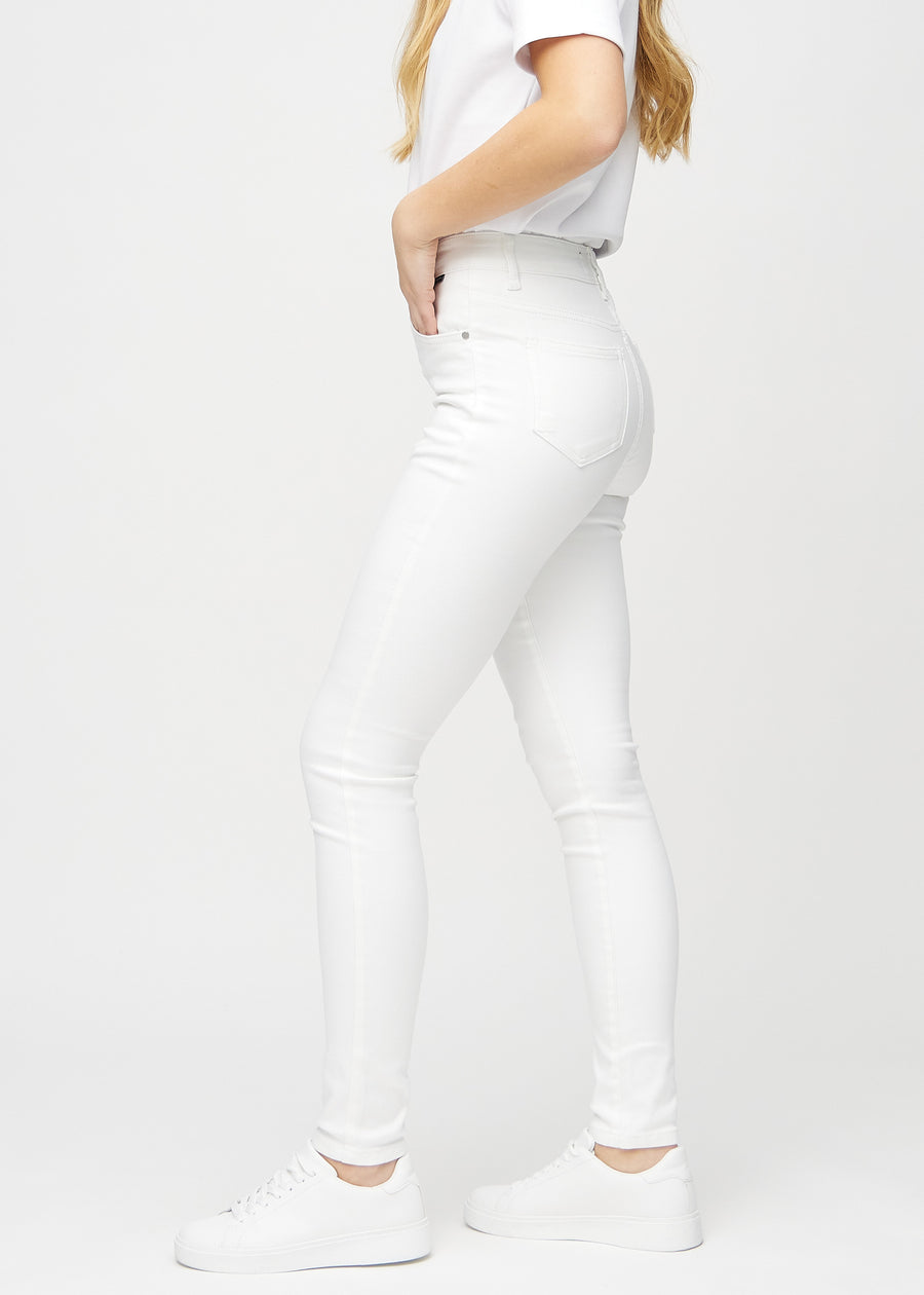 White skinny jeans seen from the side on a model.