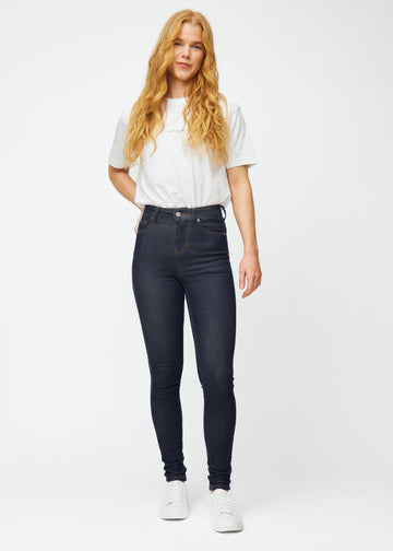 Full image of a model in deep dark blue denim jeans for women in the color Midnights with a skinny fit.