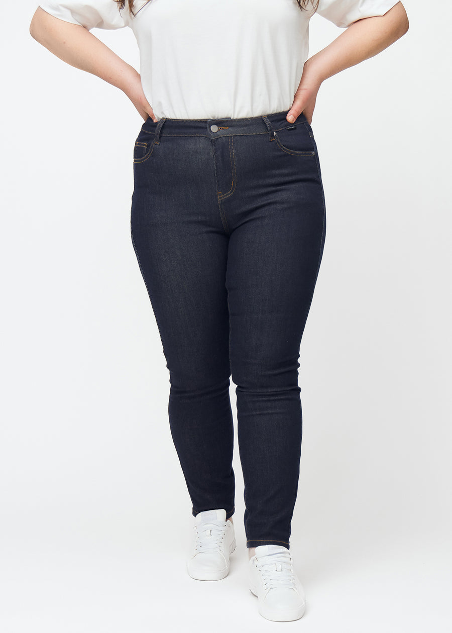 Deep dark blue denim jeans for women in the color Midnights with a skinny fit, viewed from the front on a plus-size model.