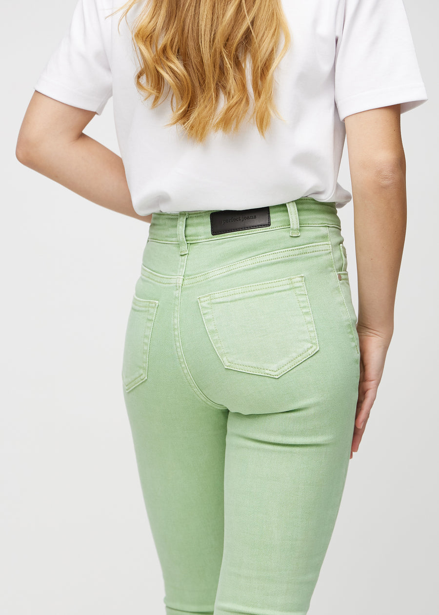 Skinny jeans for women in light green, color Mints. Close-up back view on a model, showing details.