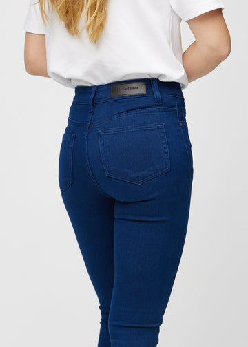 Skinny jeans for women in dark blue, color Royals. Close-up back view on a model, showing the details.