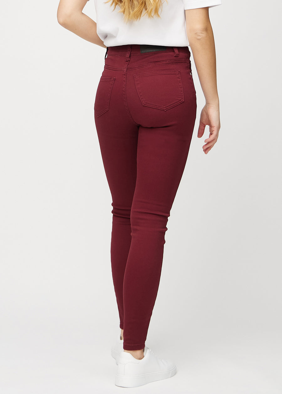 Skinny jeans for women in dark red, color Santas. Back view on a model, showing the full fit.