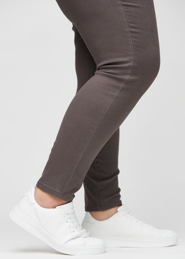 The ankles of a plus-size model, so you can see how tightly the jeans fit.