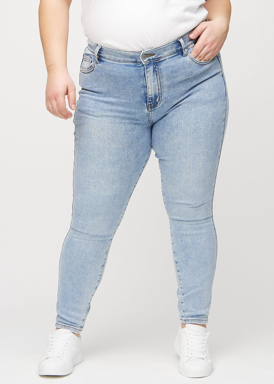 Skinny jeans for women in light blue, color Waves. Front view on a plus-size model, showing the close fit through the legs.