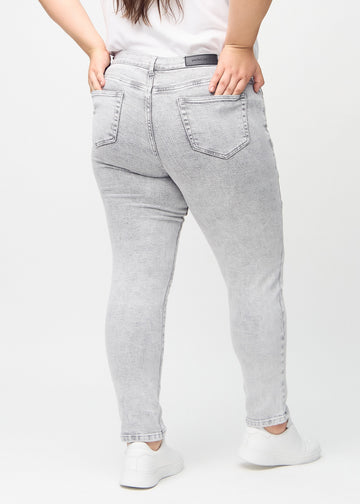 Light grey denim slim jeans seen from the back on a plus-size model, so the entire product can be seen.
