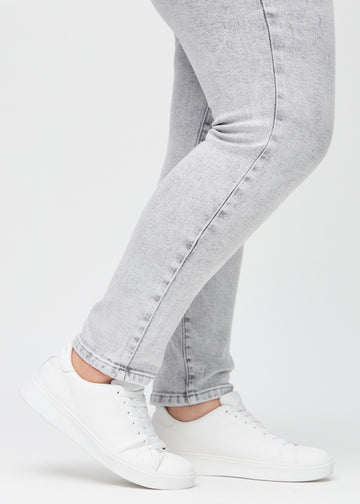 The ankles of a plus-size model, so you can see how tightly the jeans fit.