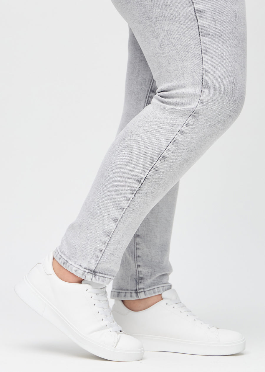 The ankles of a plus-size model, so you can see how tightly the jeans fit.