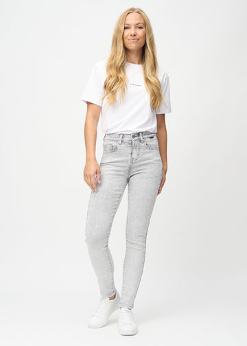 Full image of a model in light grey denim slim jeans.