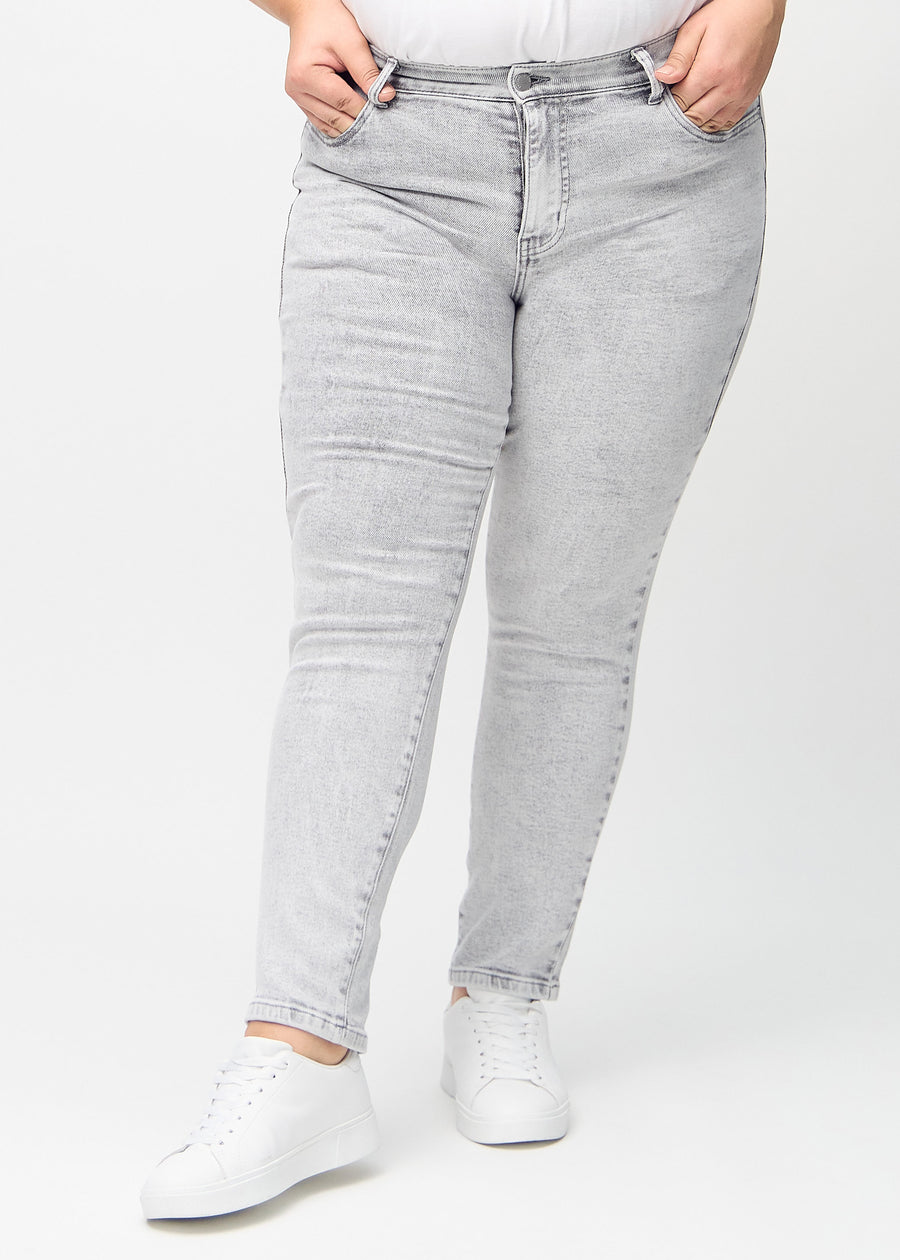 Light grey denim slim jeans, model name Ashes, which fits closely to the leg, though slightly looser at the ankle, on a plus-size model, seen from the front.