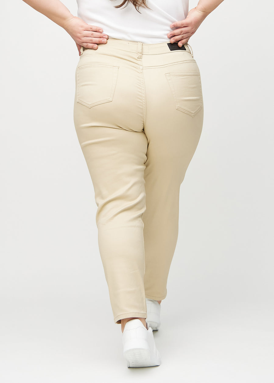 Beige slim jeans seen from behind on a plus-size model, so the entire product can be seen.