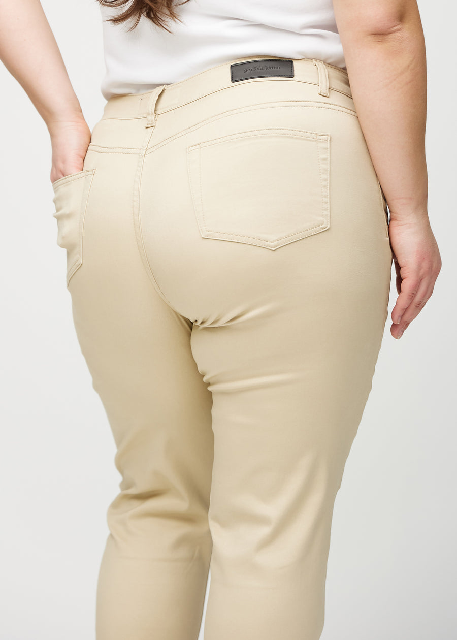 Beige slim jeans seen from behind up close on a plus-size model to show details.