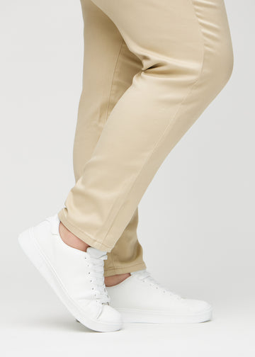 The ankles of a plus-size model, so you can see how tightly the jeans fit.