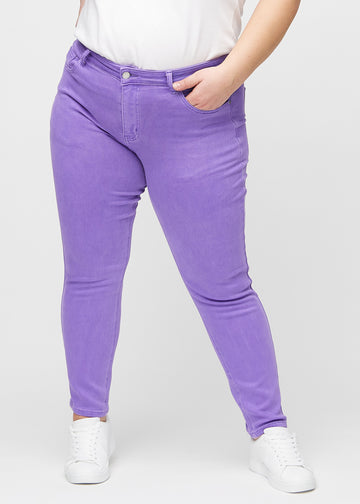 Slim jeans for women in purple, color Lavenders. Front view on a plus-size model, showing a close fit through the leg with a little more room at the ankle.