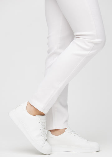 Slim jeans for women in white, color Marguerites. Close-up at the ankles on a model, showing the fit at the leg openings.