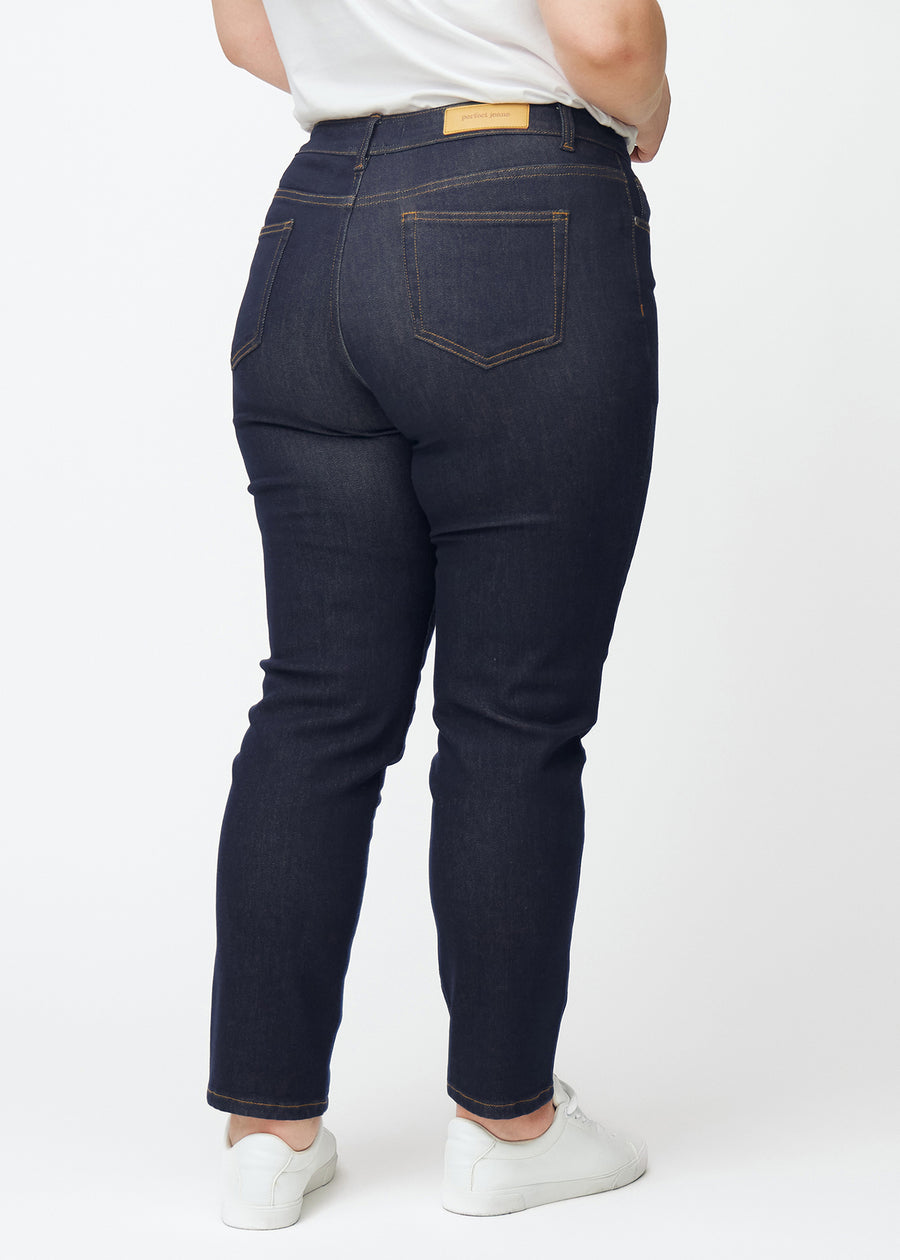 Deep dark blue denim jeans for women in the color Midnights seen from the back on a plus-size model.