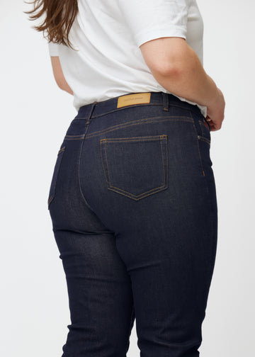 Deep dark blue denim jeans for women in the color Midnights seen from the back in close-up on a plus-size model.