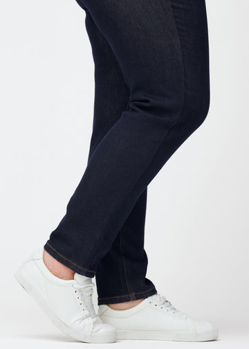 Deep dark blue denim jeans for women in the color Midnights with a slim fit shown in close-up at the ankles on a plus-size model to show the tailored finish.