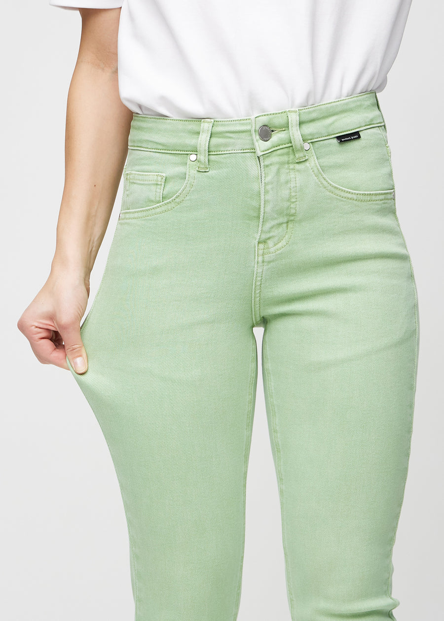 The model stretches the jeans at the thigh to show the stretch.