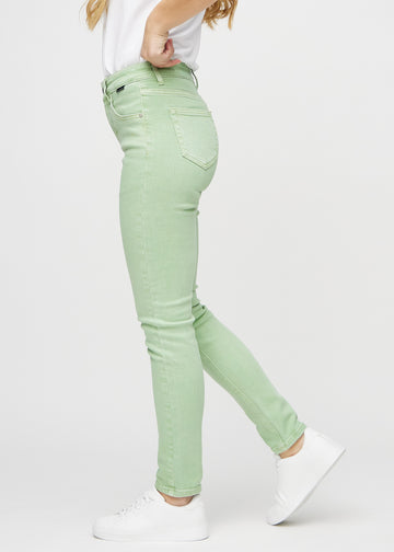 Light green slim jeans seen from the side on a model.