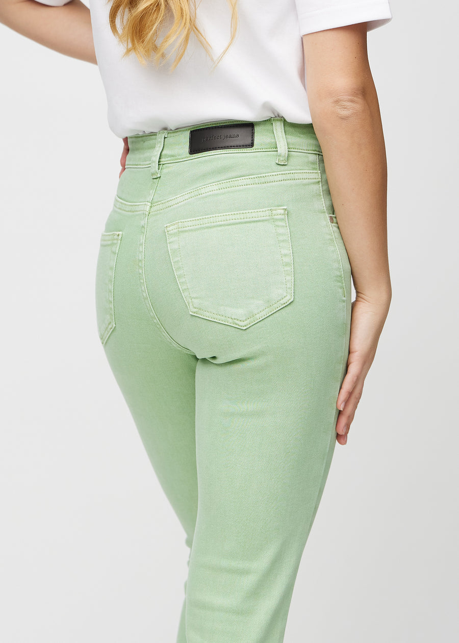 Light green slim jeans seen from the back close up to show details.