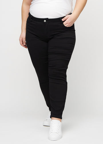 Slim jeans for women in black, color Ravens. Front view on a plus-size model, showing a close fit through the leg with a little more room at the ankle.