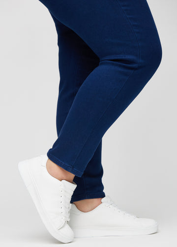 The ankles of a plus-size model, so you can see how tightly the jeans fit.
