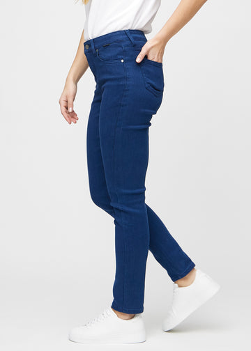 Dark blue slim jeans seen from the side on a model.