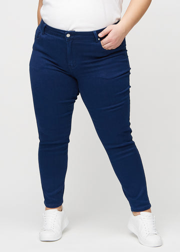 Dark blue slim jeans, model name Royals, which fits close to the leg, though slightly looser at the ankle, on a plus-size model, seen from the front.